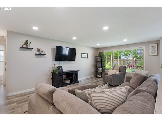 living area featuring baseboards, recessed lighting, and light wood-type flooring