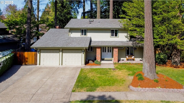 traditional home featuring covered porch, a garage, fence, a front lawn, and concrete driveway