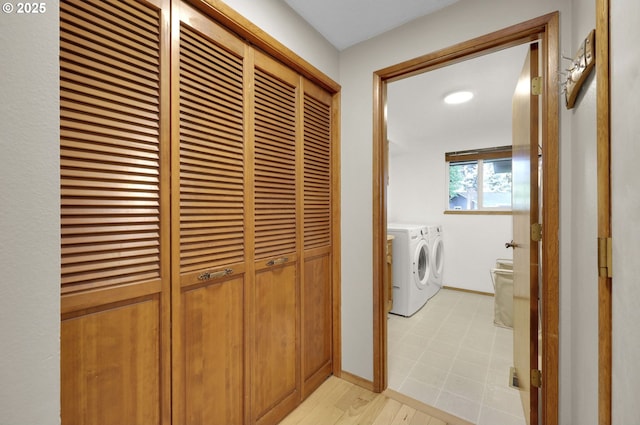 washroom featuring baseboards, laundry area, and washing machine and clothes dryer