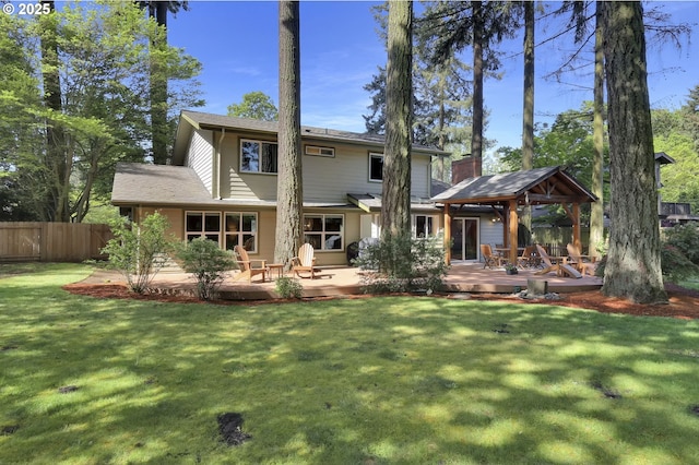 rear view of house with a gazebo, a lawn, fence, and a deck