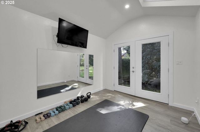 exercise area with french doors, baseboards, wood finished floors, and vaulted ceiling