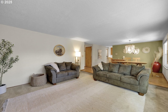 living room featuring a textured ceiling, a chandelier, and light colored carpet