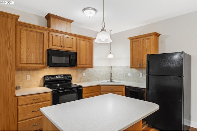 kitchen featuring black appliances, backsplash, sink, and hanging light fixtures