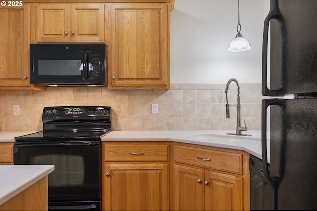 kitchen featuring black appliances, pendant lighting, sink, and tasteful backsplash