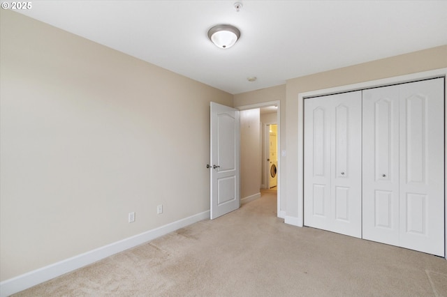 unfurnished bedroom with a closet and light colored carpet