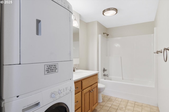 full bathroom featuring vanity,  shower combination, tile patterned flooring, toilet, and stacked washing maching and dryer