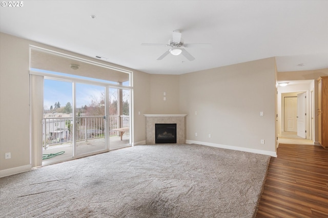 unfurnished living room featuring ceiling fan and dark hardwood / wood-style floors