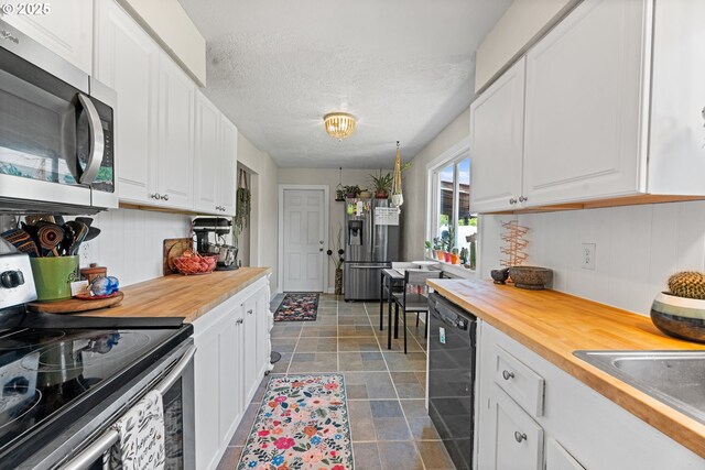 8015 NE 90th Ave, Vancouver, WA 98662 - kitchen with stainless steel appliances, butcher block counters, white cabinetry, a sink, and a textured ceiling