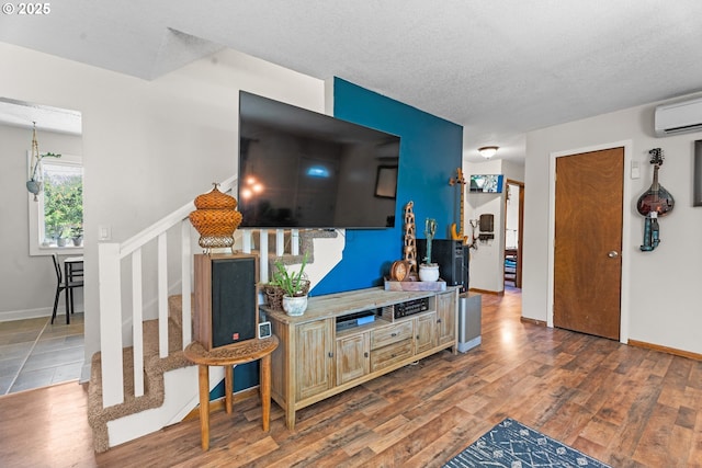 8015 NE 90th Ave, Vancouver, WA 98662 - living room featuring wood finished floors, a wall mounted AC, a textured ceiling, stairs, and baseboards