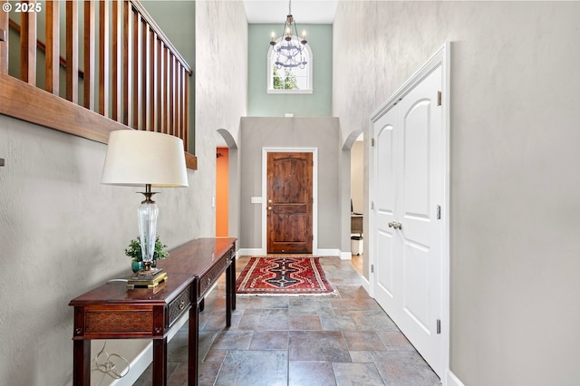 380 Mountaingate Dr, Springfield, OR 97478 - foyer entrance with stone finish flooring, arched walkways, a chandelier, and a towering ceiling