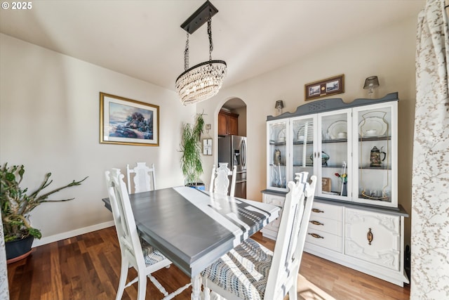 dining room with dark hardwood / wood-style flooring and a notable chandelier