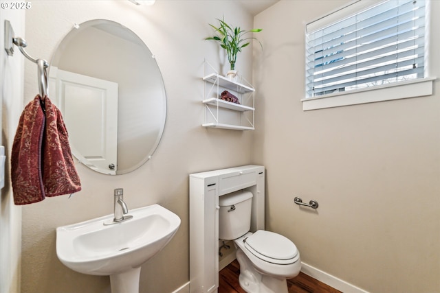 bathroom with hardwood / wood-style flooring, toilet, and sink