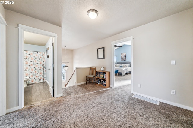 carpeted empty room with a textured ceiling