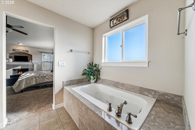 bathroom with ceiling fan, tiled tub, tile patterned flooring, and a wealth of natural light