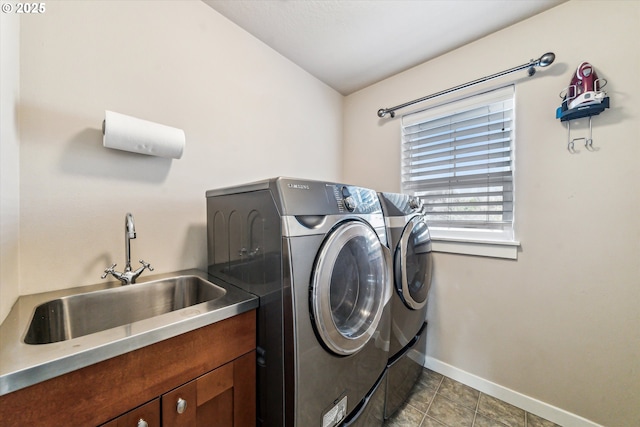 washroom featuring cabinets, light tile patterned flooring, sink, and washing machine and clothes dryer