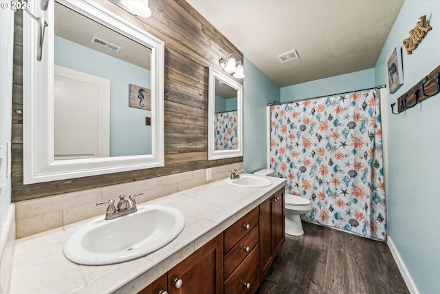 bathroom with vanity, hardwood / wood-style floors, tasteful backsplash, and toilet