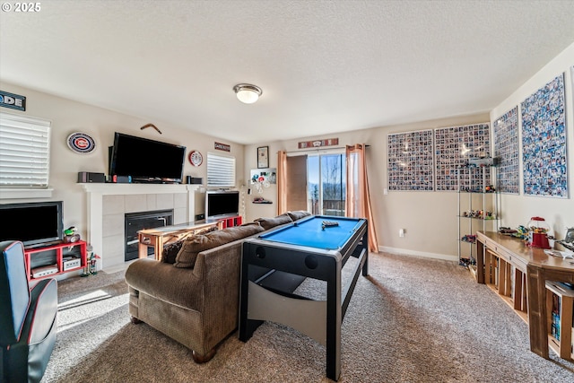 recreation room with a fireplace, carpet, and a textured ceiling