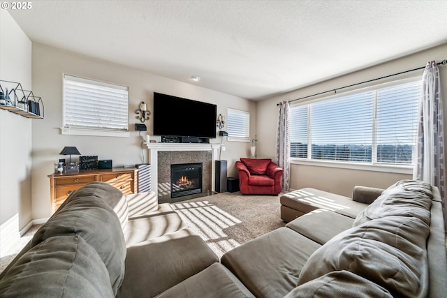 carpeted living room featuring a tiled fireplace and a textured ceiling