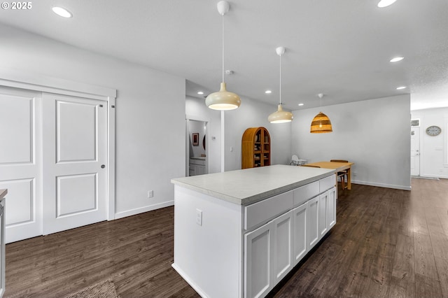 kitchen featuring recessed lighting, a kitchen island, white cabinets, and dark wood-type flooring