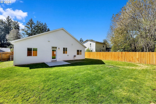 rear view of house featuring a lawn, a fenced backyard, and a patio area