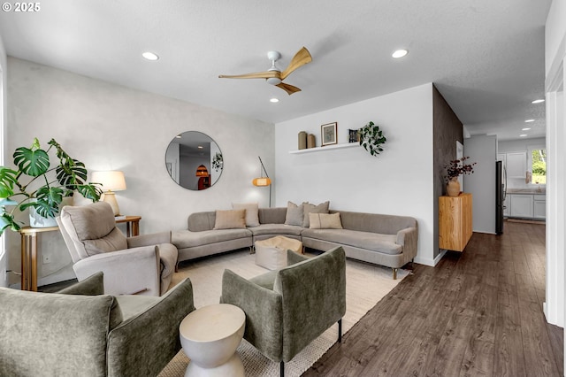 living area with baseboards, a ceiling fan, wood finished floors, and recessed lighting