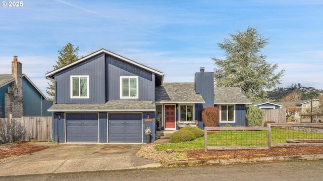 split level home with a garage, concrete driveway, a chimney, roof with shingles, and fence