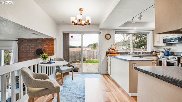 kitchen with visible vents, dark countertops, stainless steel appliances, light wood-type flooring, and a chandelier