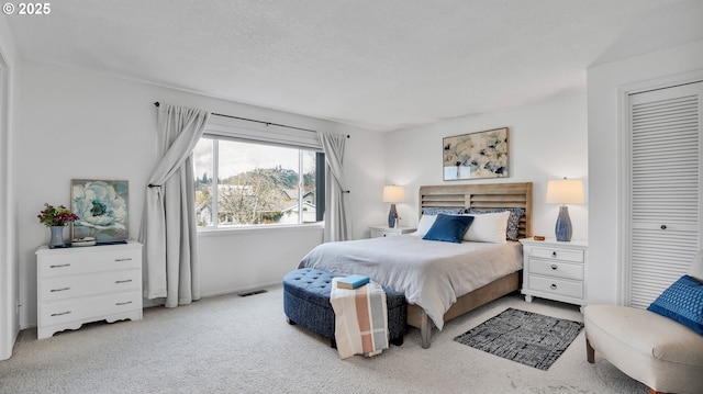 carpeted bedroom with visible vents and a textured ceiling