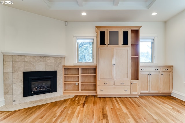 unfurnished living room featuring light hardwood / wood-style floors and a tile fireplace