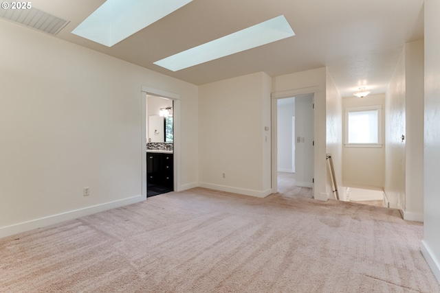 interior space with light colored carpet and a skylight