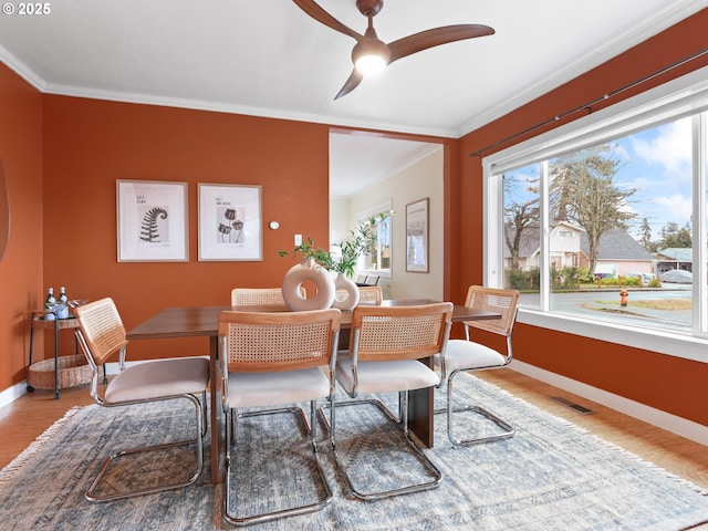 dining space featuring ornamental molding, wood-type flooring, and plenty of natural light