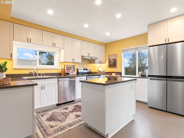 kitchen with sink, stainless steel appliances, a center island, and white cabinets