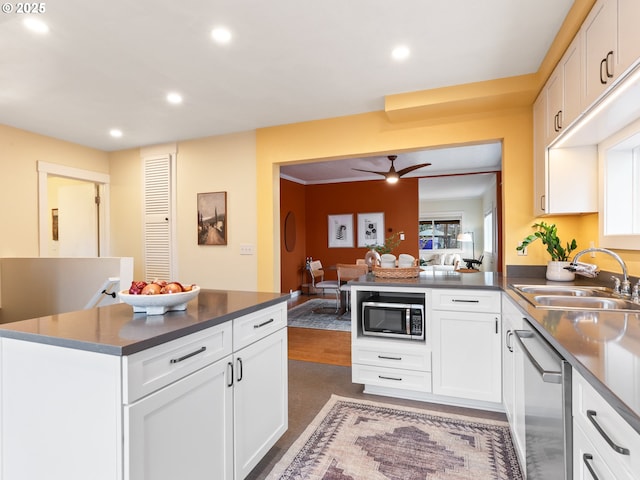 kitchen with stainless steel appliances, sink, white cabinets, and kitchen peninsula