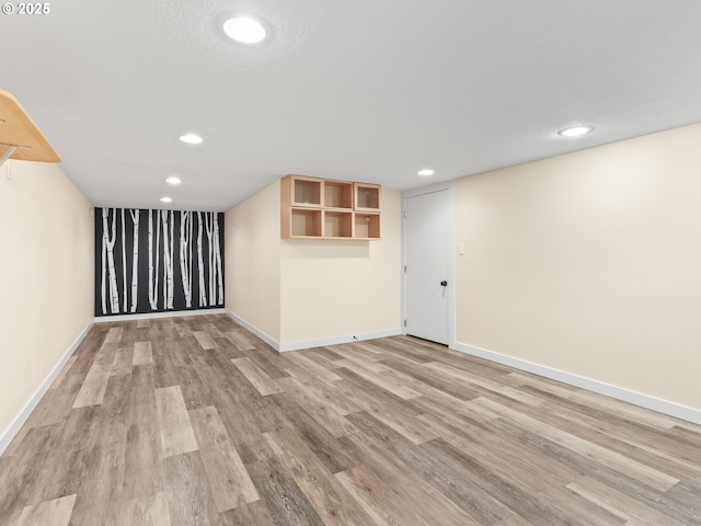 basement with light hardwood / wood-style floors and a textured ceiling