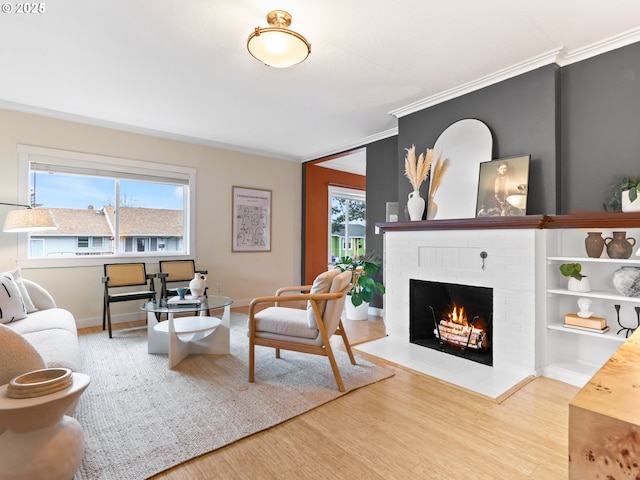 living room with a brick fireplace, crown molding, and hardwood / wood-style floors