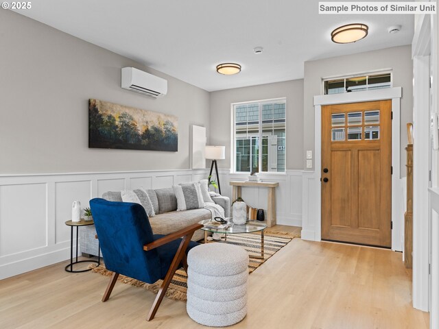 4585 N Haight Ave, Portland, OR 97217 - living area featuring a wall unit AC, a wainscoted wall, a decorative wall, wood finished floors, and stairway