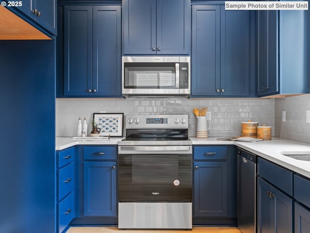 4585 N Haight Ave, Portland, OR 97217 - kitchen featuring dishwasher, a sink, blue cabinetry, and light countertops