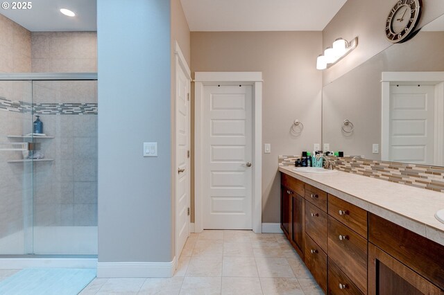 bathroom featuring vanity, an enclosed shower, tile patterned floors, and decorative backsplash