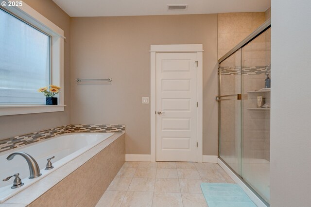 bathroom with independent shower and bath and tile patterned flooring