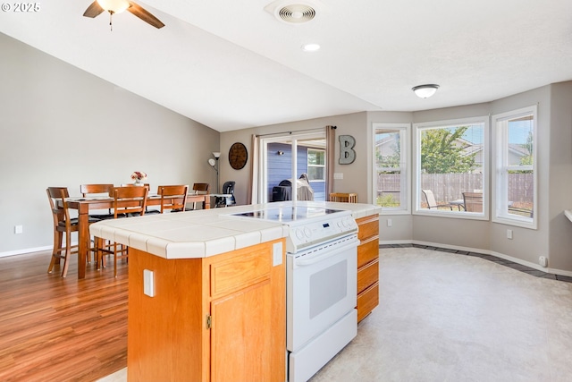 4870 Dorrance Loop NE, Salem, OR 97305 - kitchen featuring white electric range oven, tile counters, ceiling fan, and a center island