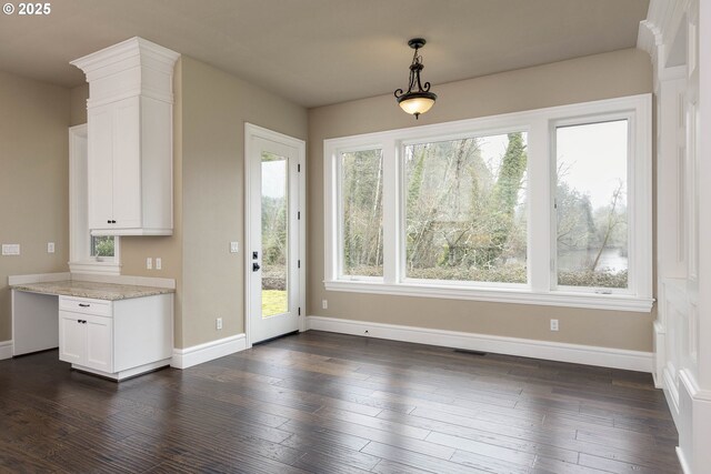 kitchen with appliances with stainless steel finishes, white cabinetry, dark hardwood / wood-style flooring, custom exhaust hood, and light stone counters