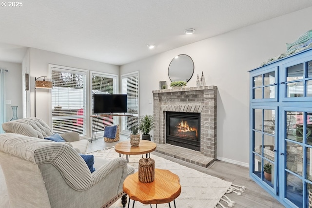 living room with a fireplace, baseboards, and wood finished floors