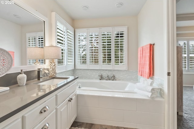 full bath featuring a garden tub and vanity