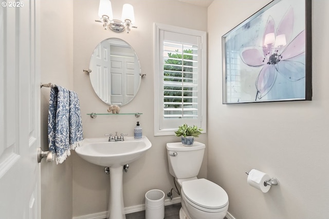 bathroom featuring a sink, toilet, and baseboards