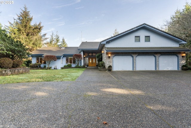 view of front of home with a front yard and a garage