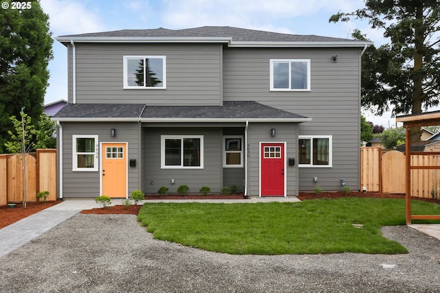 view of front of property featuring roof with shingles, a front yard, fence, and a gate