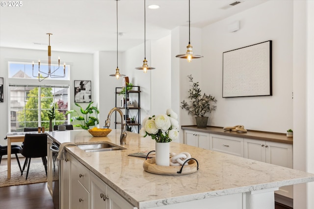 kitchen featuring a sink, white cabinetry, a chandelier, light stone countertops, and recessed lighting