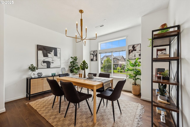 dining room with a chandelier, dark wood-style floors, and baseboards