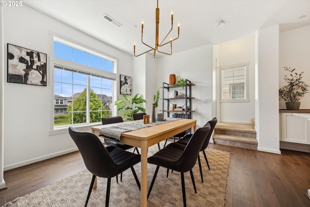 dining space with a chandelier, plenty of natural light, wood finished floors, and baseboards