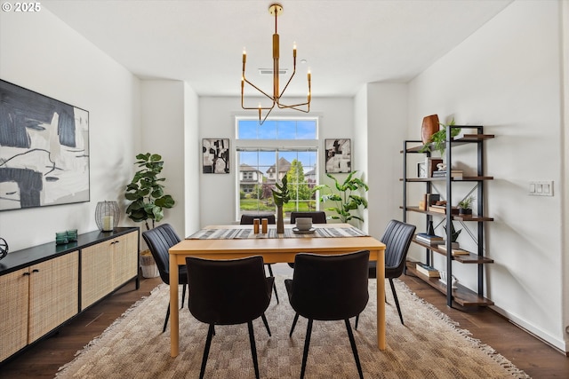 dining area featuring a chandelier and dark wood-type flooring